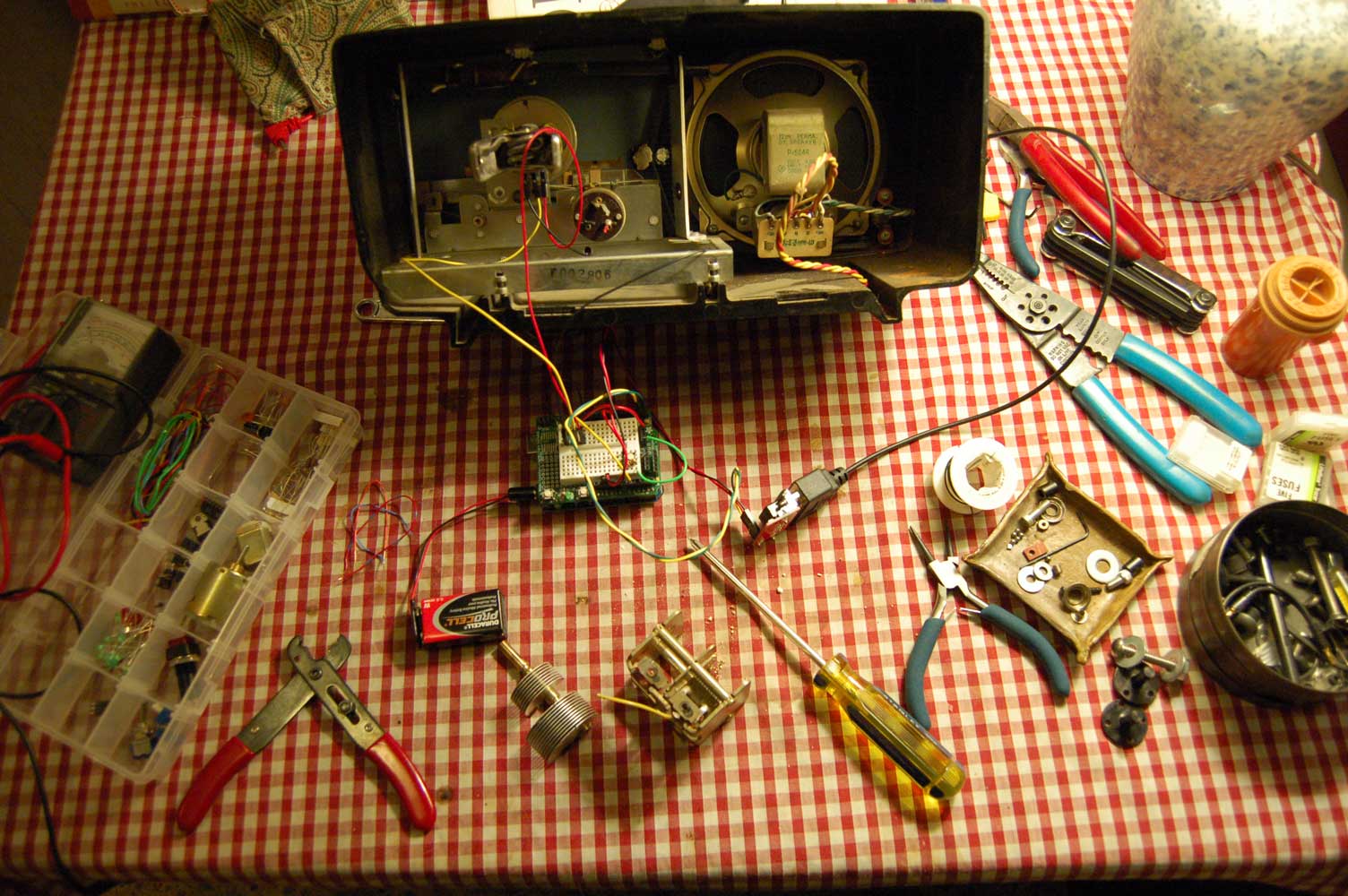 Open transistor radio with tools and wires on tabletop
